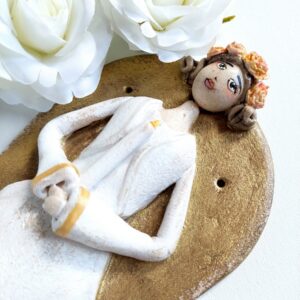 Wisząc figurka przedstawiająca dziewczynkę komunijną w wianku i ze świecą