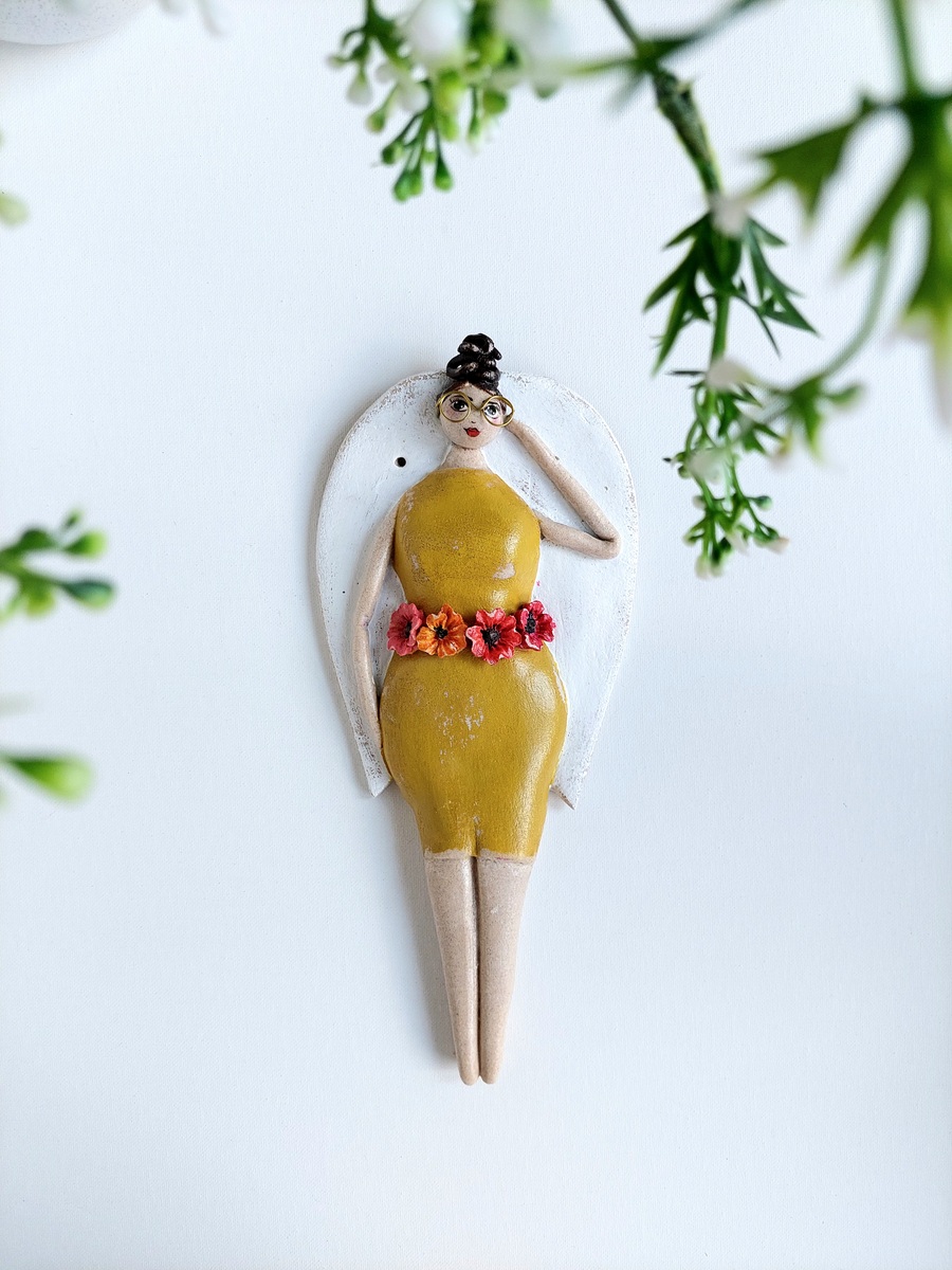 Anioł w okularach i żółtej sukience dla kobiety z klasą