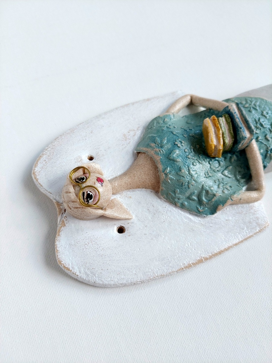 Figurka anioła trzymająca stos książek